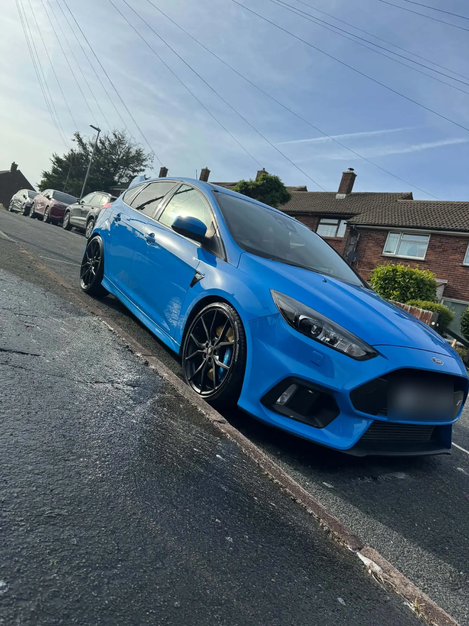 Nitrous blue Ford Focus RS after a full exterior detail, paintwork reflecting the sky on a wet street