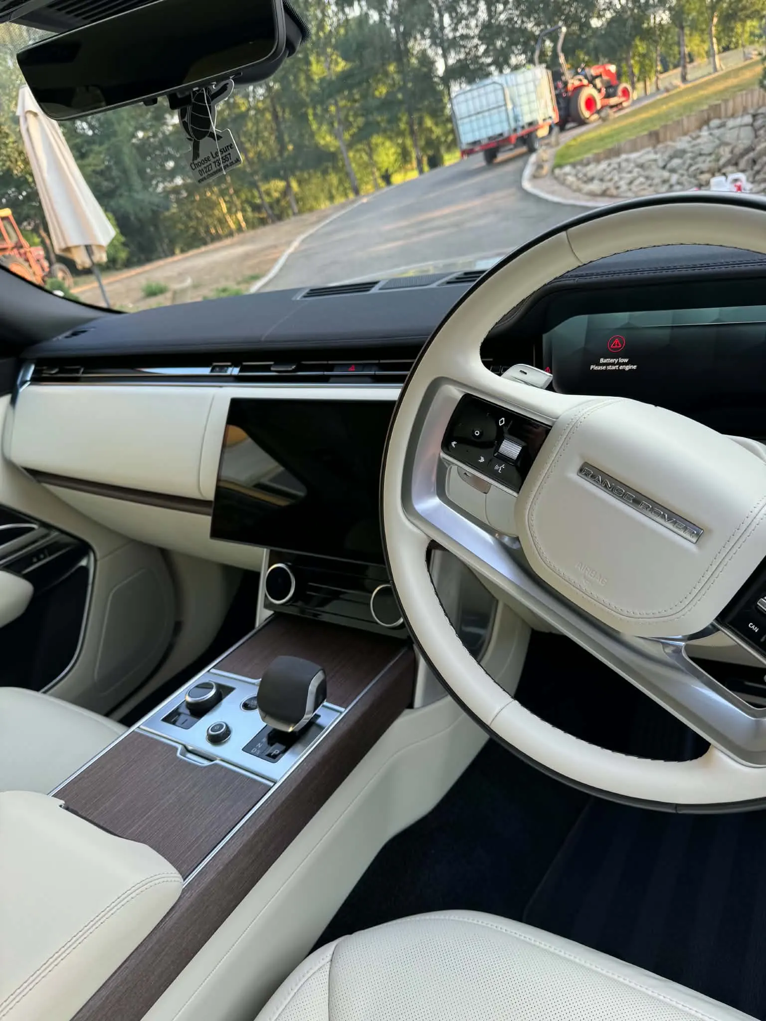 Cream leather seats, wood trim and centre console of a Range Rover after a premium interior detail