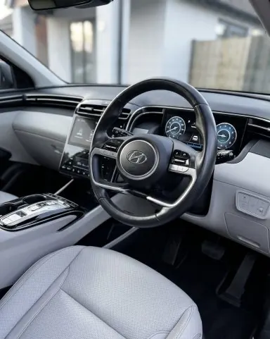 Steering wheel, dashboard and light grey seats of an SUV after an interior detail