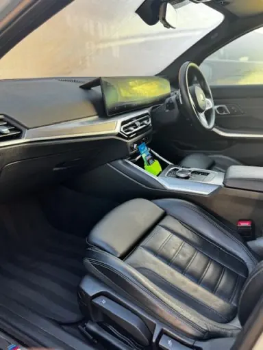 Black leather seats and centre console after a premium interior detail