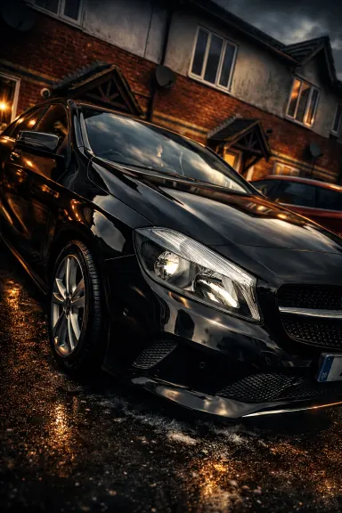 Black Mercedes photographed at night after a machine polish, showing deep reflections