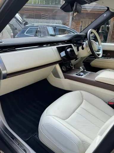 Cream leather front seats and dashboard of a luxury SUV after a premium interior detail