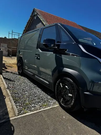 Dark green van after a full exterior detail on a gravel driveway