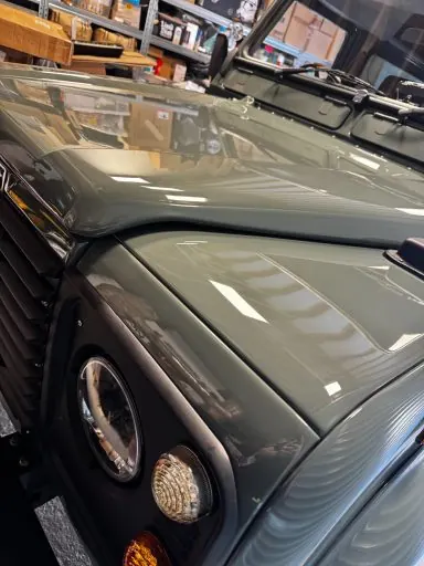 Front end of a dark Land Rover Defender after an exterior detail